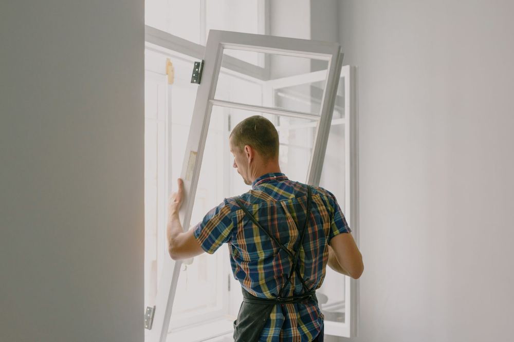 Menuisier installant une fenêtre